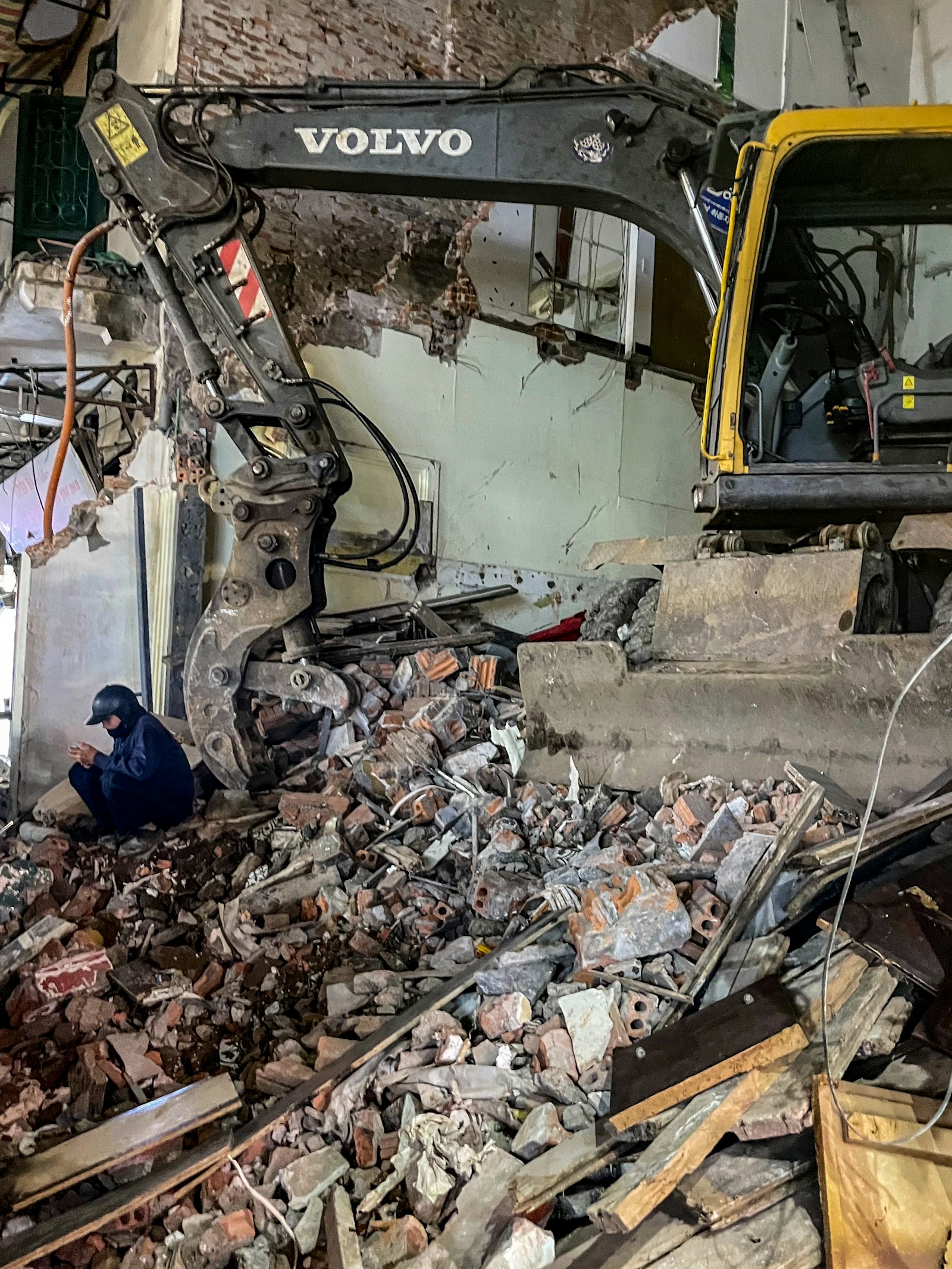 Excavator working at a building demolition site with debris | Westside Construction Group