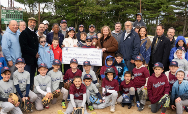 Officials and young baseball players hold a ceremonial check on a ballfield in Rockville Centre | Westside Construction Group