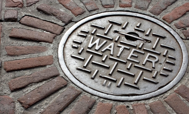 Manhole cover with the word Water printed on it | Westside Construction Group