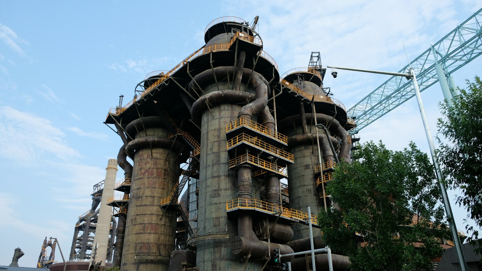 Industrial blast furnaces with yellow metal staircases against a blue sky | Westside Construction Group