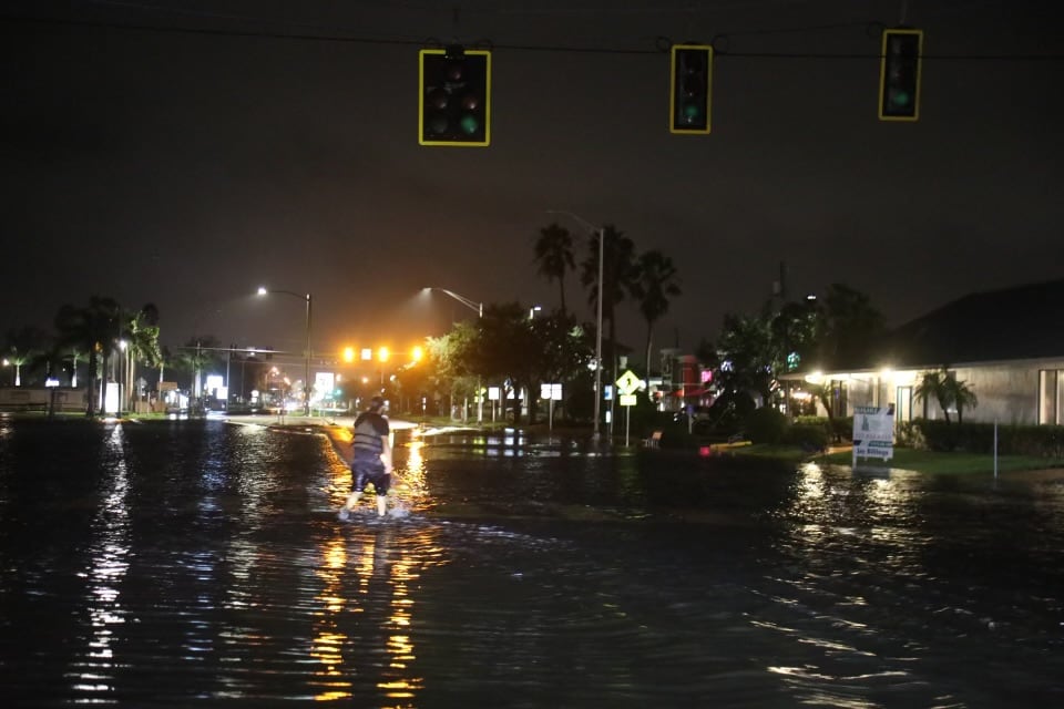 Man crossing a flooded Fourth Street N in St. Petersburg after Hurricane Helene storm surge | Westside Construction Group