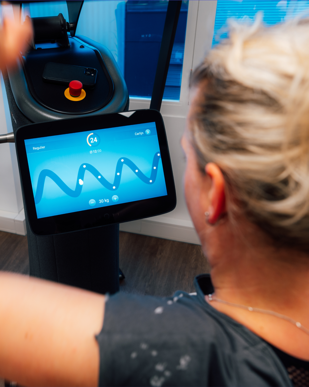 Person using fitness machine with touchscreen displaying workout progress and settings.