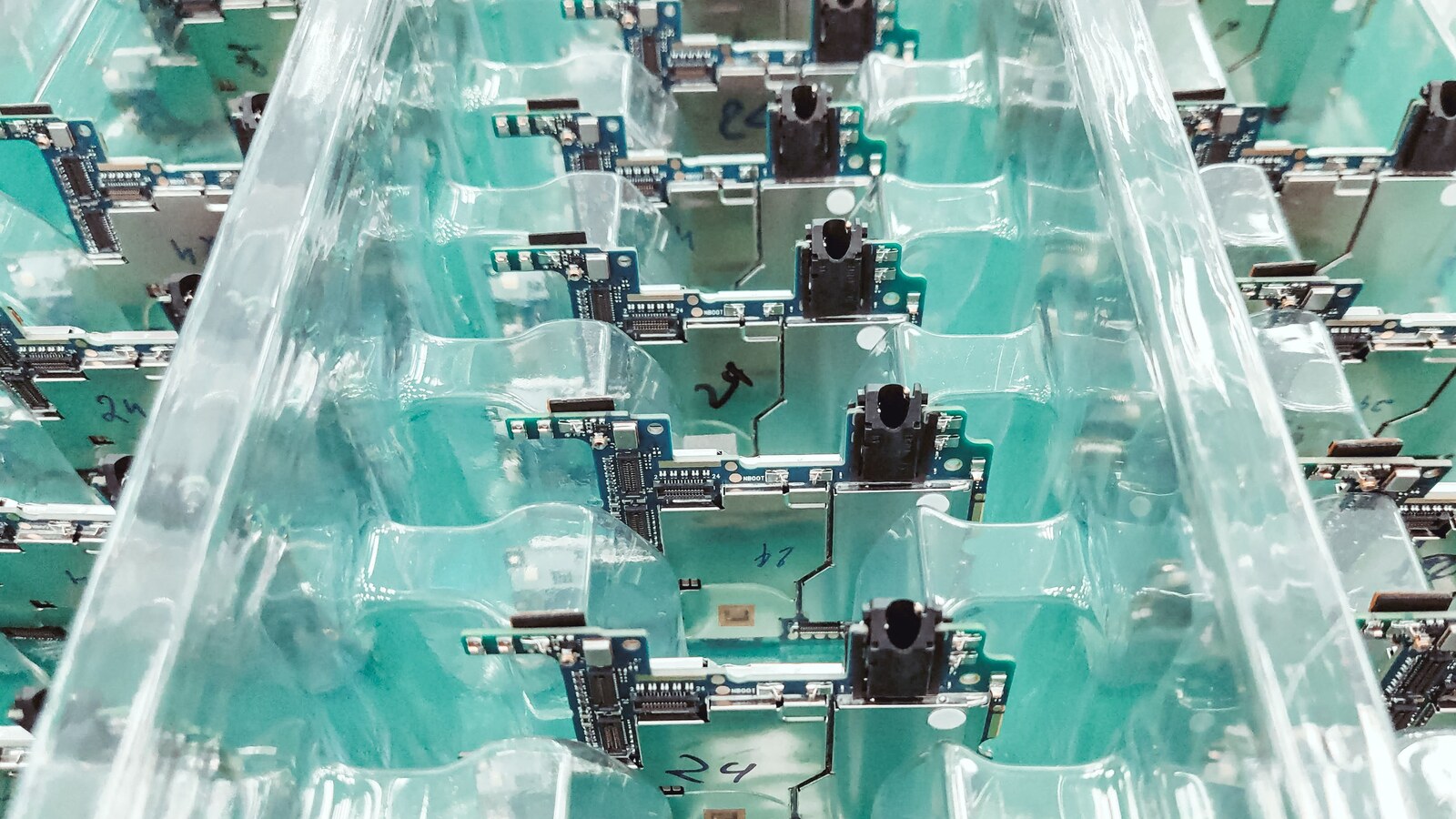 Rows of populated electronic circuit boards arranged in a production setting.