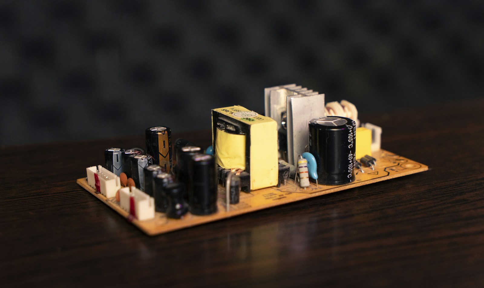 Illustrative power-supply circuit board with capacitors, a transformer and a heatsink