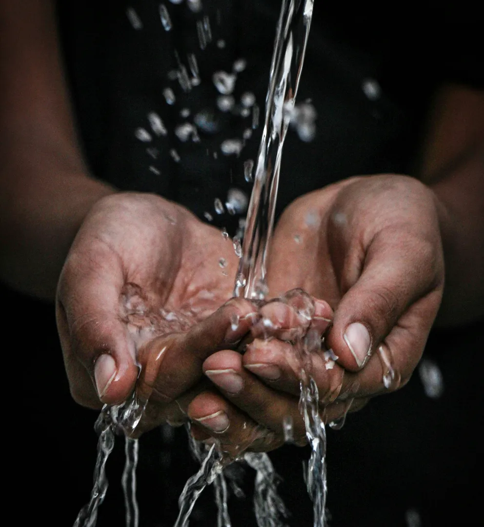 Cupped hands catching falling water