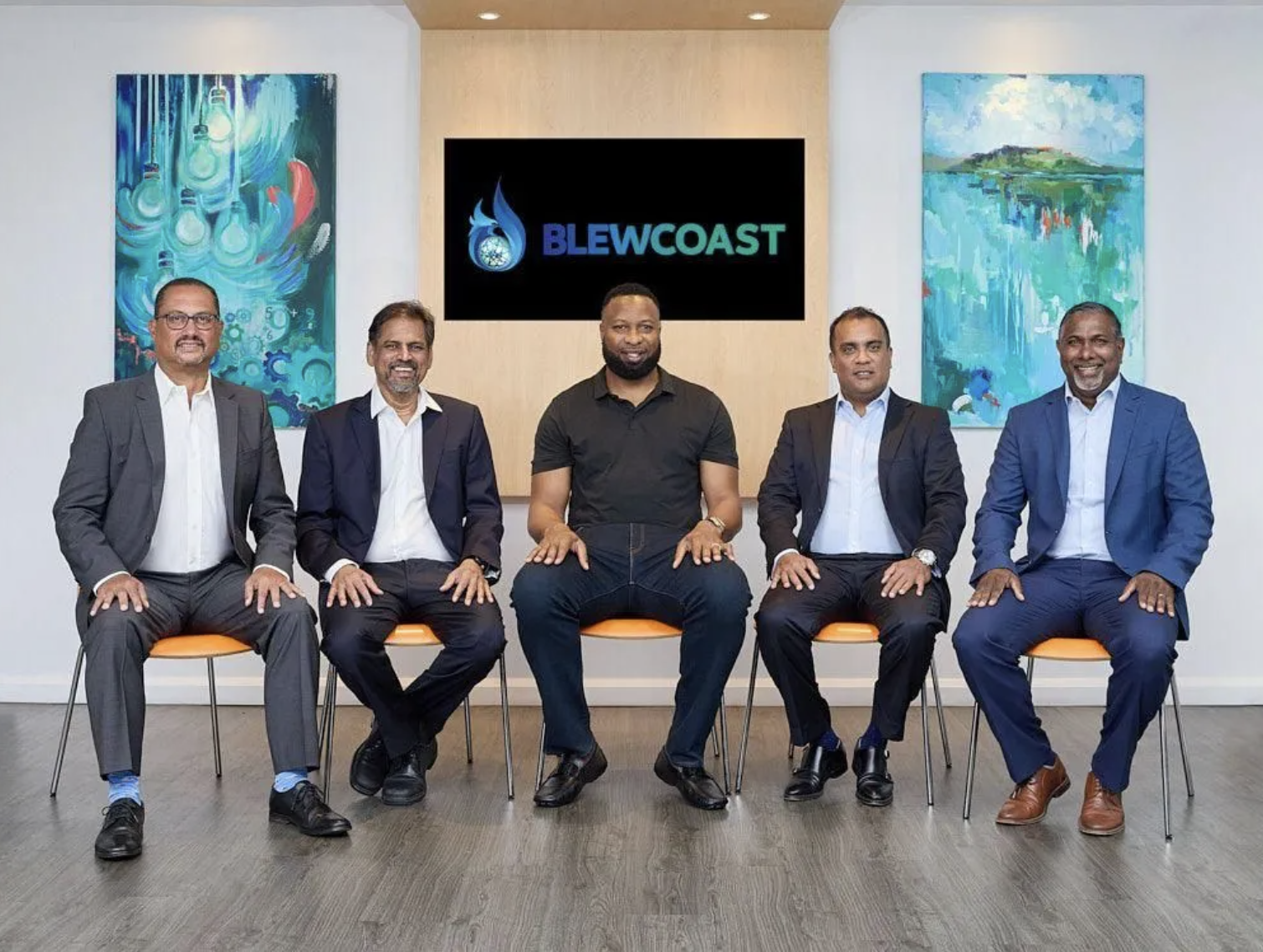 The Blewcoast environmental consultancy team seated in front of the company logo