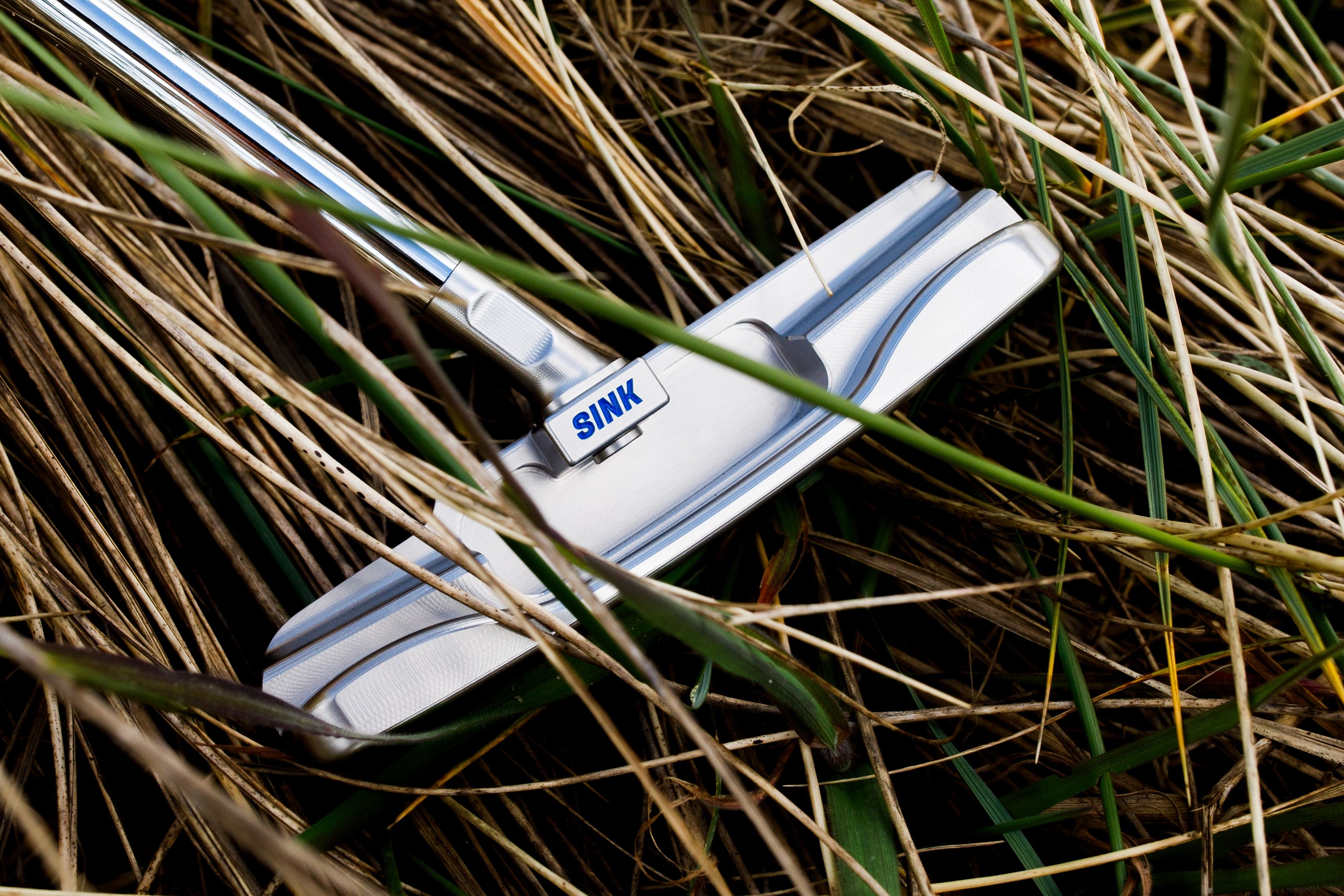Product photography for SINK Golf's Anchor Line putter, shot on location in coastal environments including tidal pools, wet sand and running water.