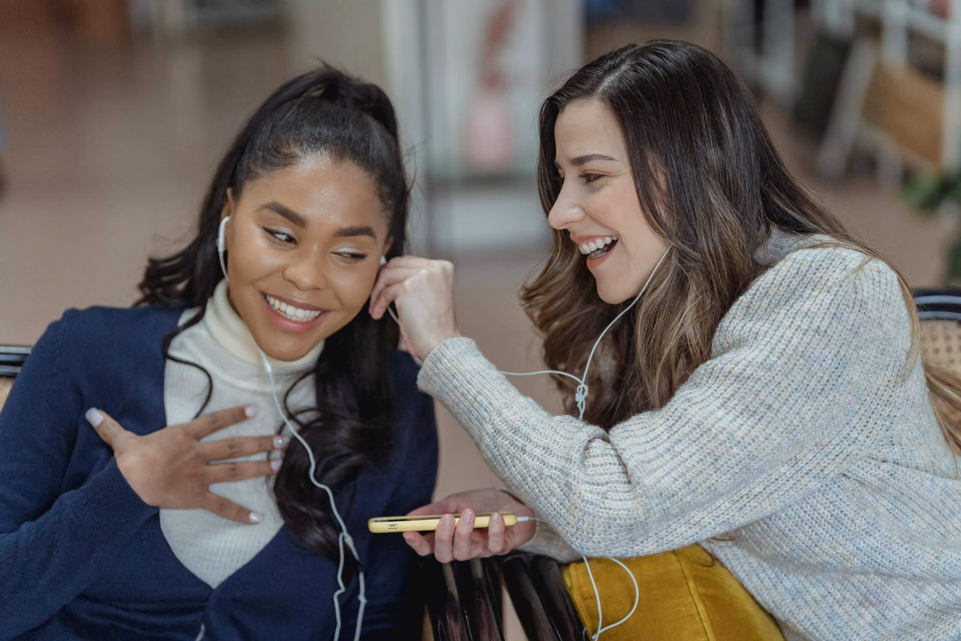 Diverse happy women listening to music with smartphone and earphones