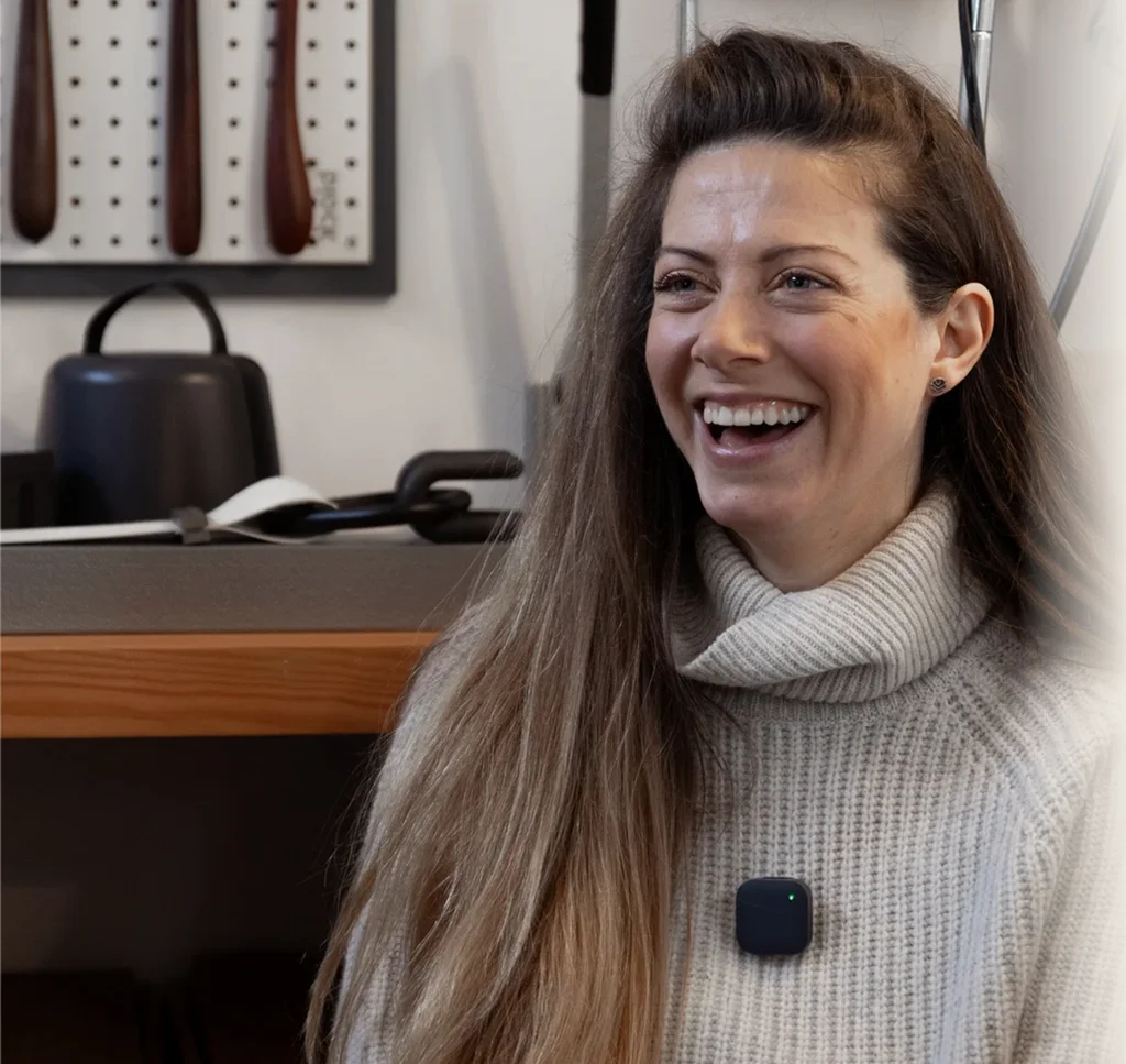 Person laughing while wearing a small clip-on wireless microphone