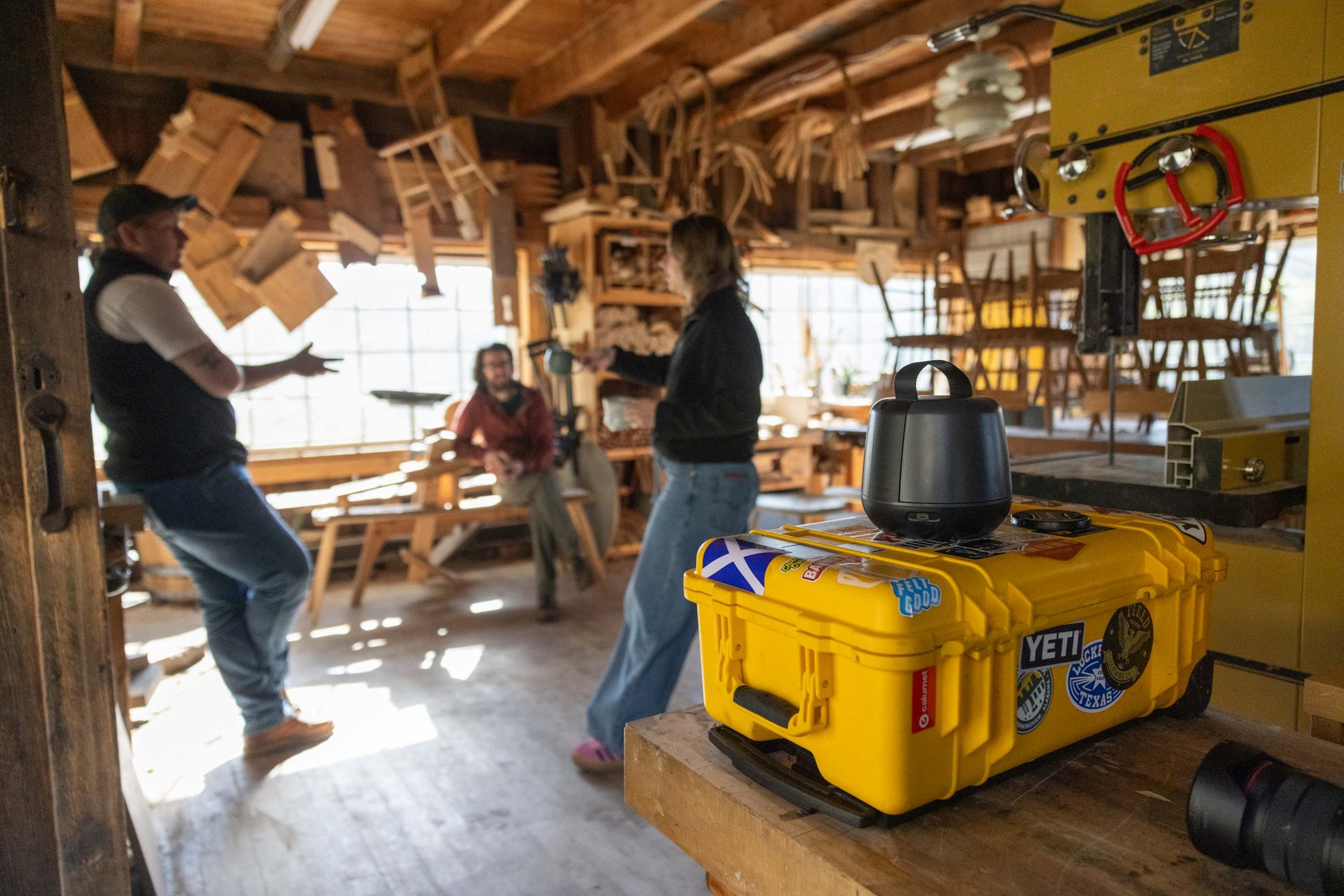Wide view of a busy woodworking workshop during a We Are Makers recording session with the Sound Capsule case on a bench