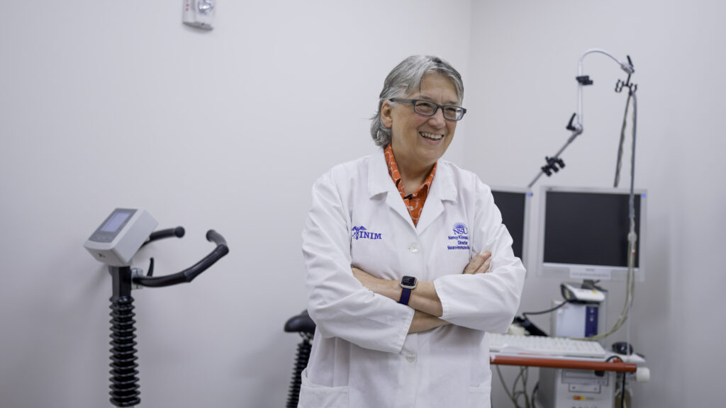 a woman in a white lab coat standing in a room