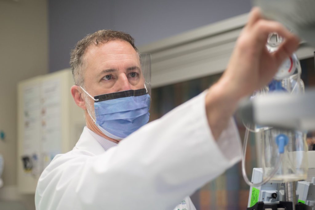 a man in a lab coat and face mask
