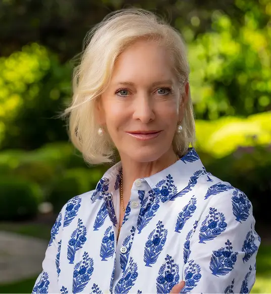 a woman with blonde hair wearing a blue and white shirt