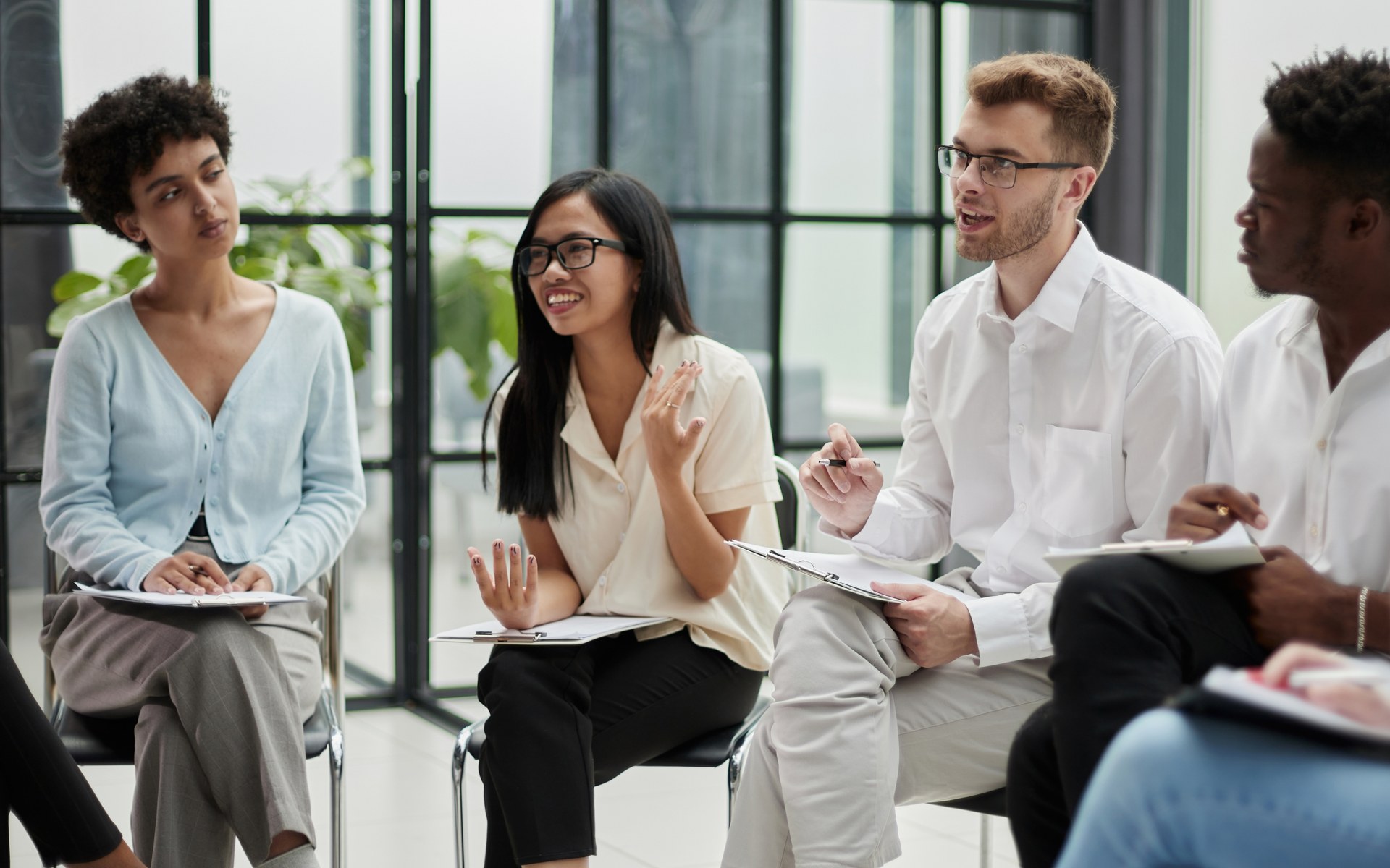 Professionals seated in a training session, listening and taking notes