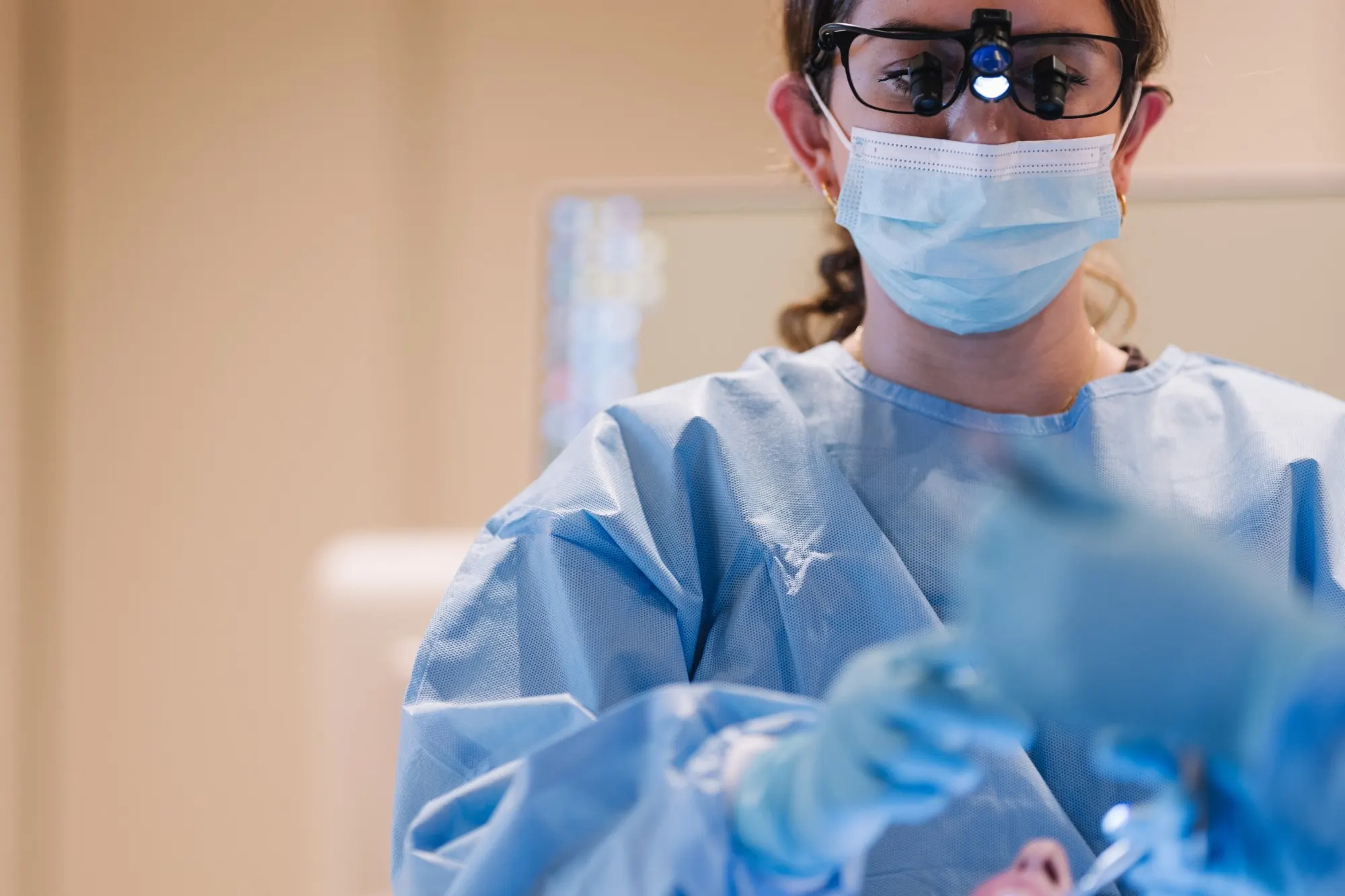 Dr Payvand Menhadji in surgical gown and loupes