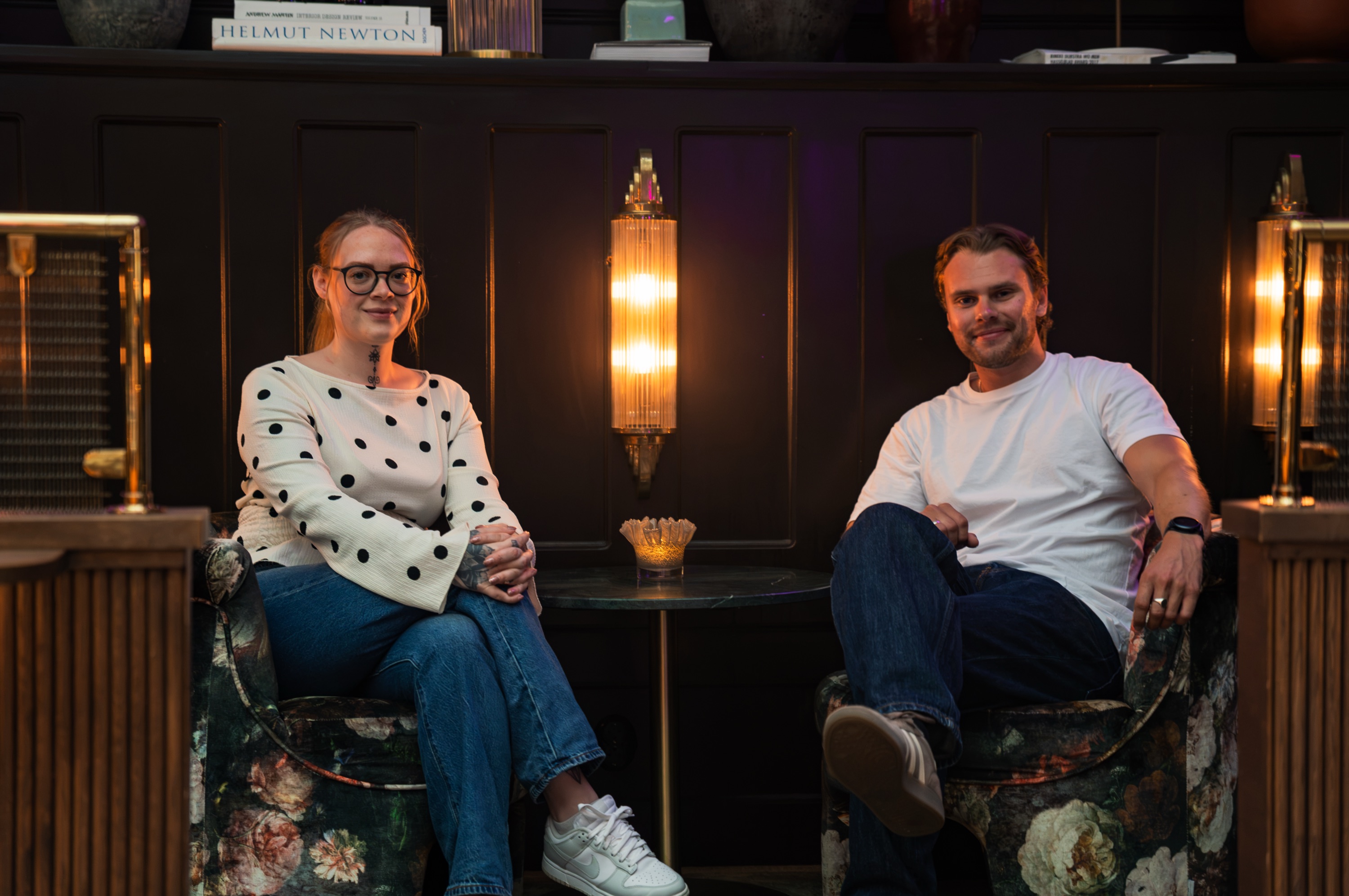 Mikaela Rasmusson och Theo Skogsberg sitter i varsin fåtölj i en art nouveau-lounge i Malmö.