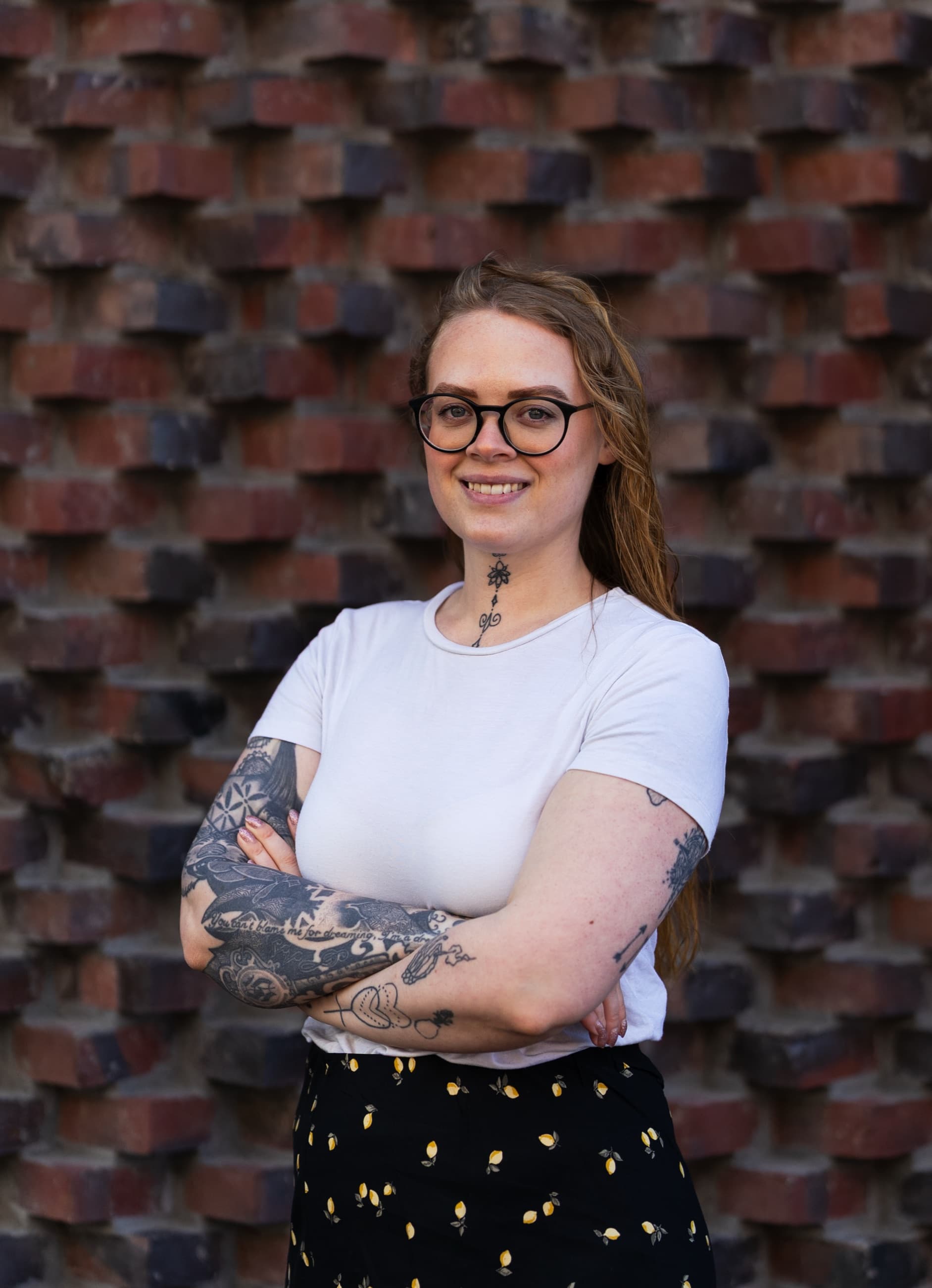 Mikaela Rasmusson framför en tegelvägg.