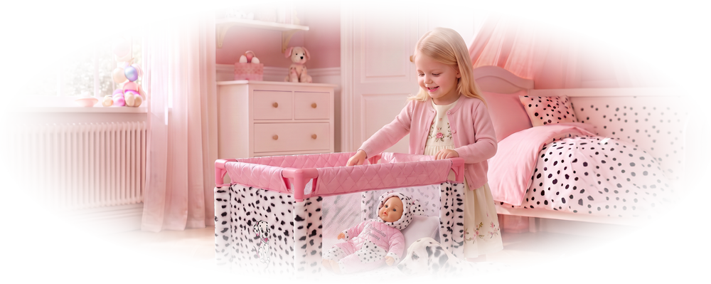 Smiling girl stands by a pink spotted playpen with a doll inside and a Dalmatian puppy nearby.