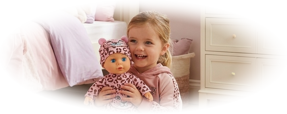 Two girls in pink pajamas play in a pastel bedroom with a matching doll and carrier bag.