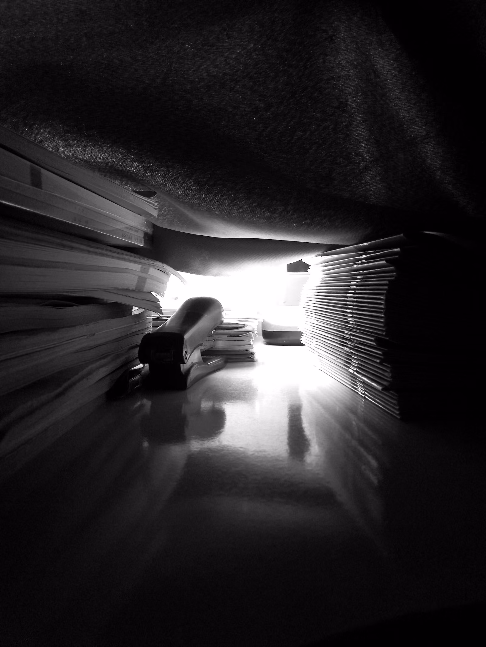 Stosy dokumentów i zszywacz w przytłumionym świetle — narastające sprawy podatkowe