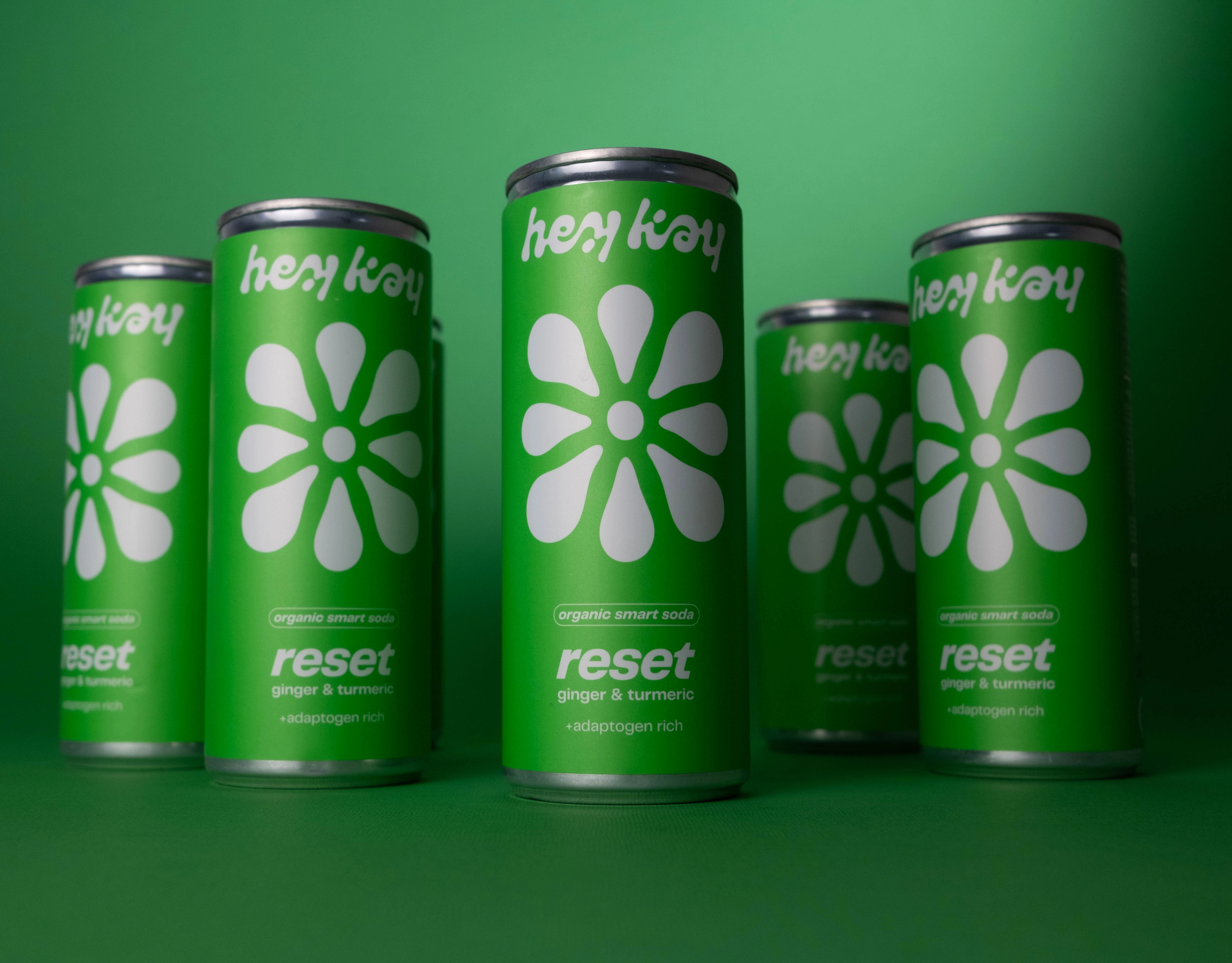 Five hey kay reset cans on a green background
