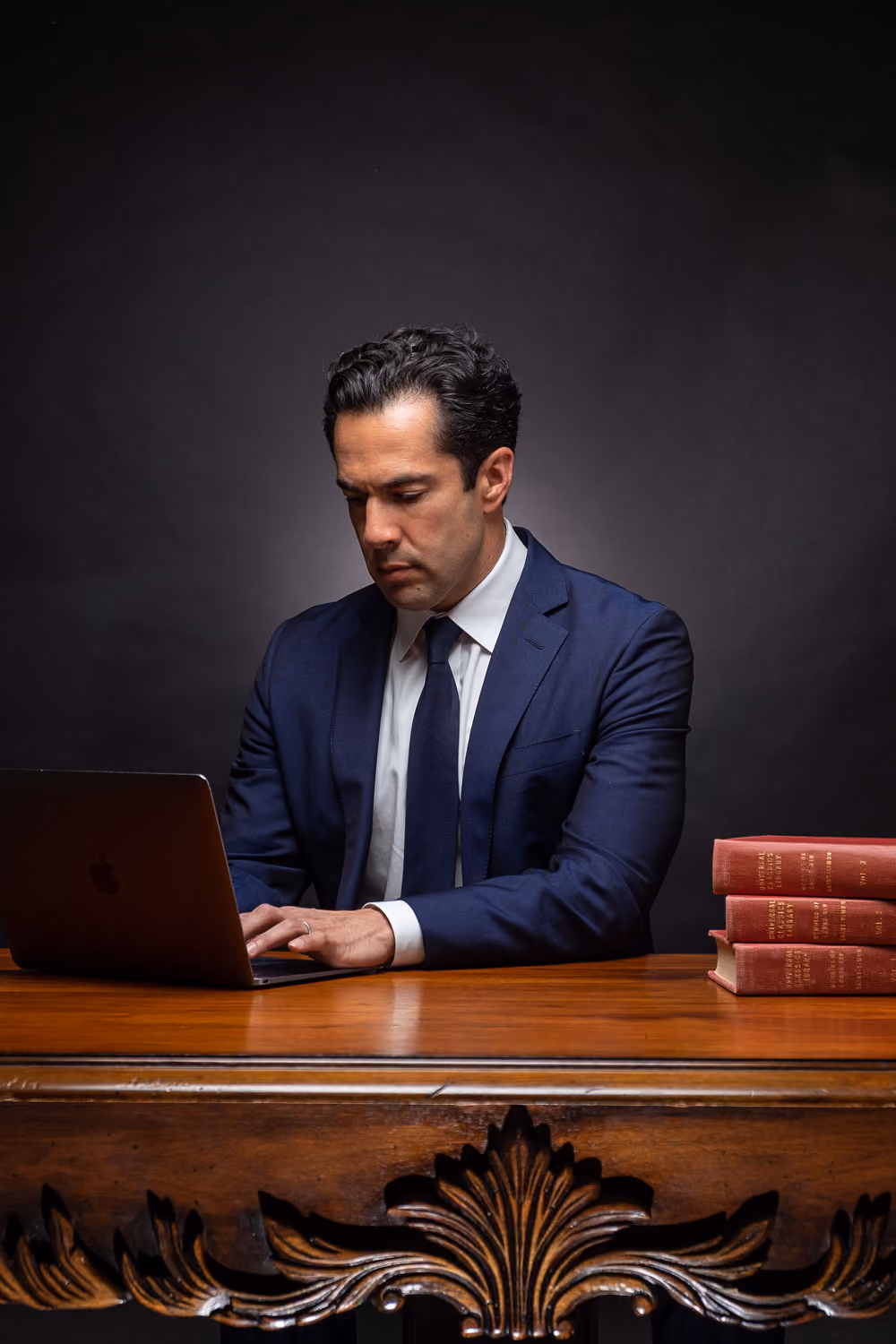 Marco Crawford, professional lawyer and attorney, working at wooden desk with legal books.