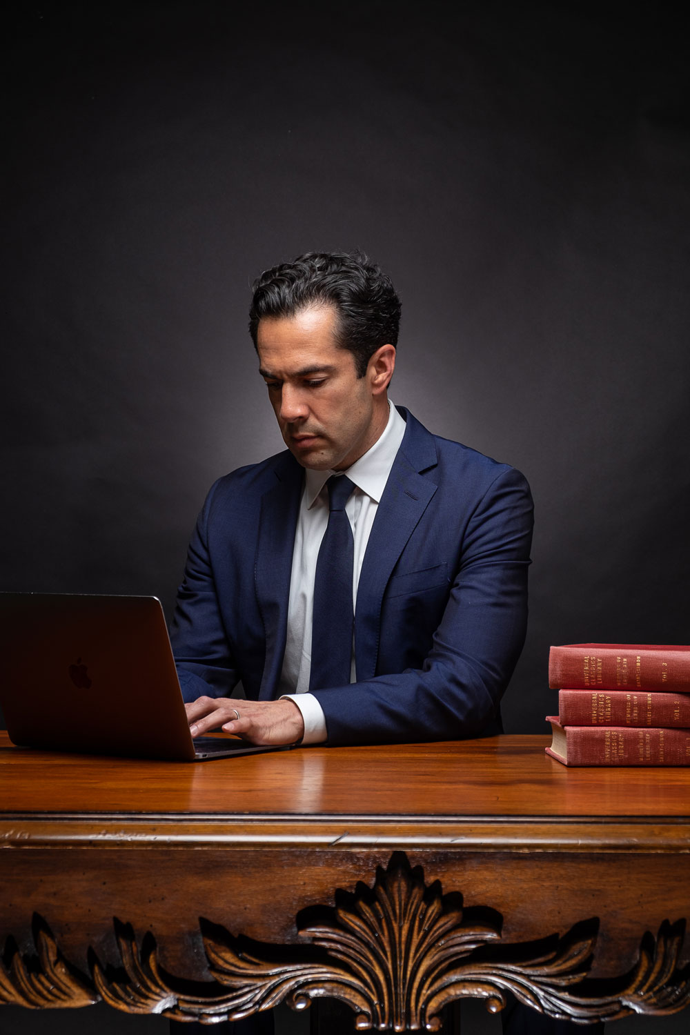 Marco Crawford, professional lawyer and attorney, working at wooden desk with legal books.