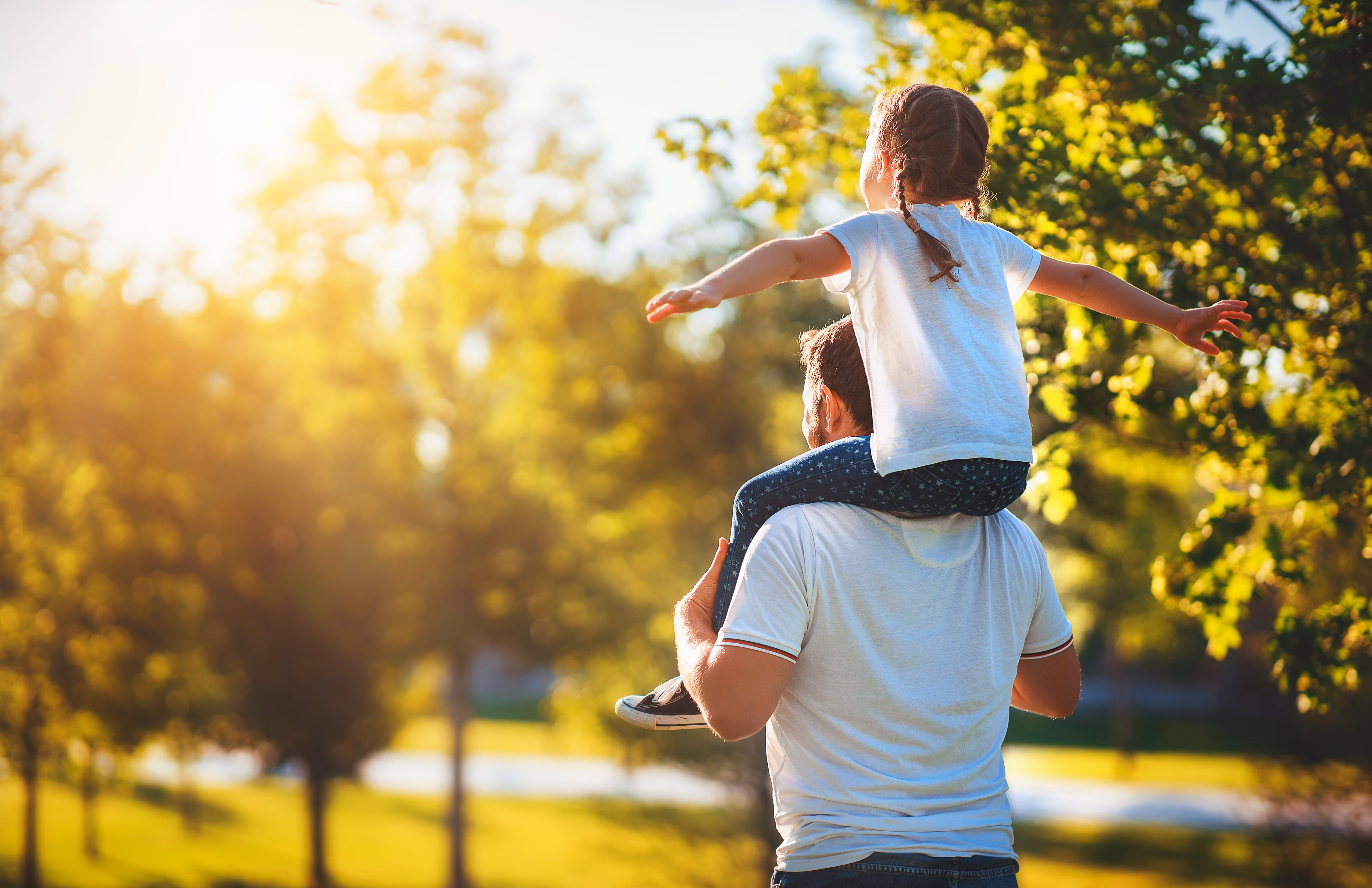 Man giving child a shoulder ride stock image