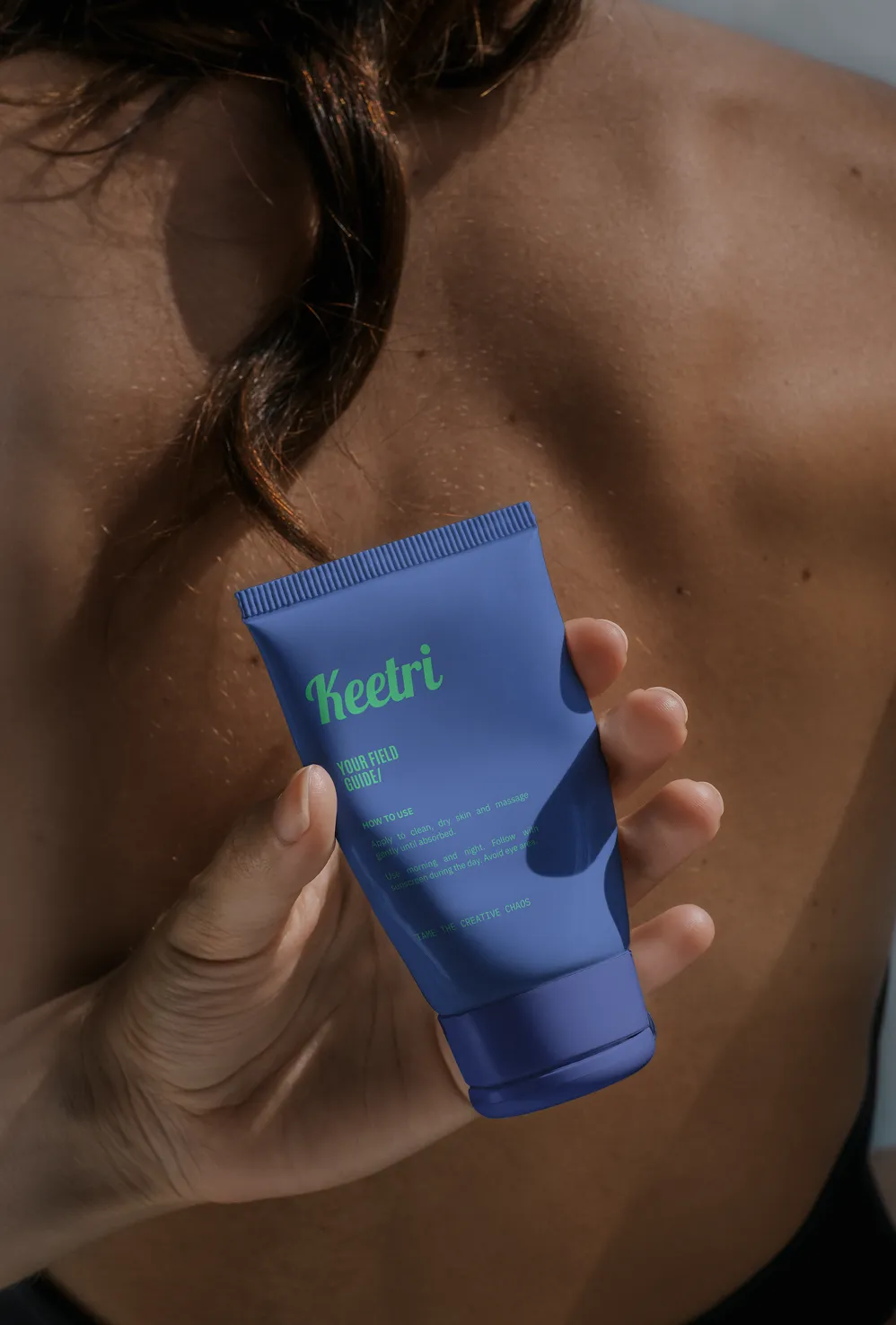 Hand holding a Keetri-branded tube labeled 'Your Field Guide'