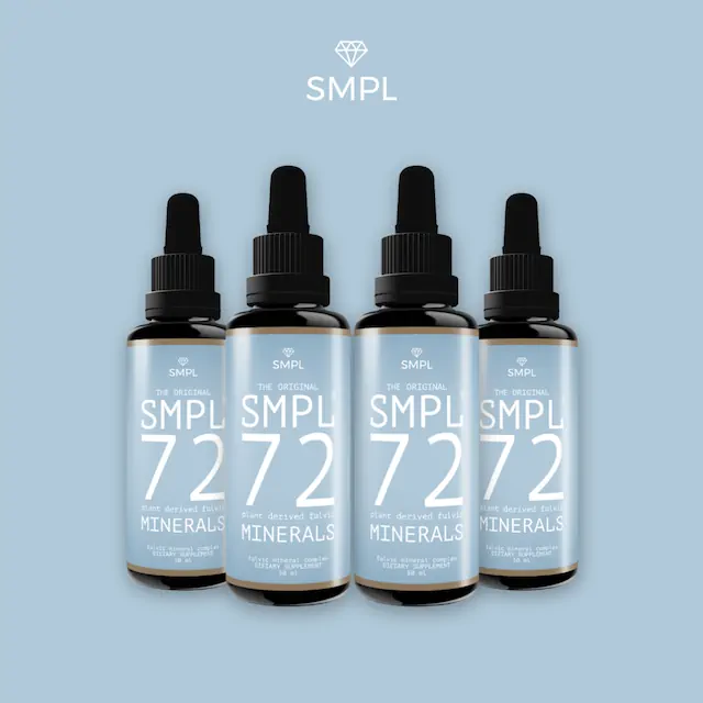 Vier donkere flesjes met druppelaar met label SMPL 72 Plant Derived Fulvic Minerals op blauwe achtergrond.