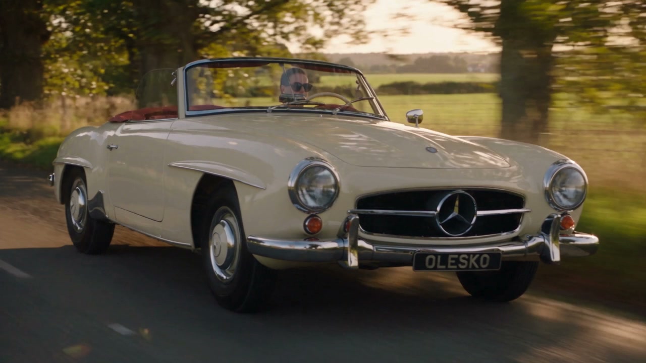 Bone Mercedes-Benz 190 SL on a tree-lined country avenue