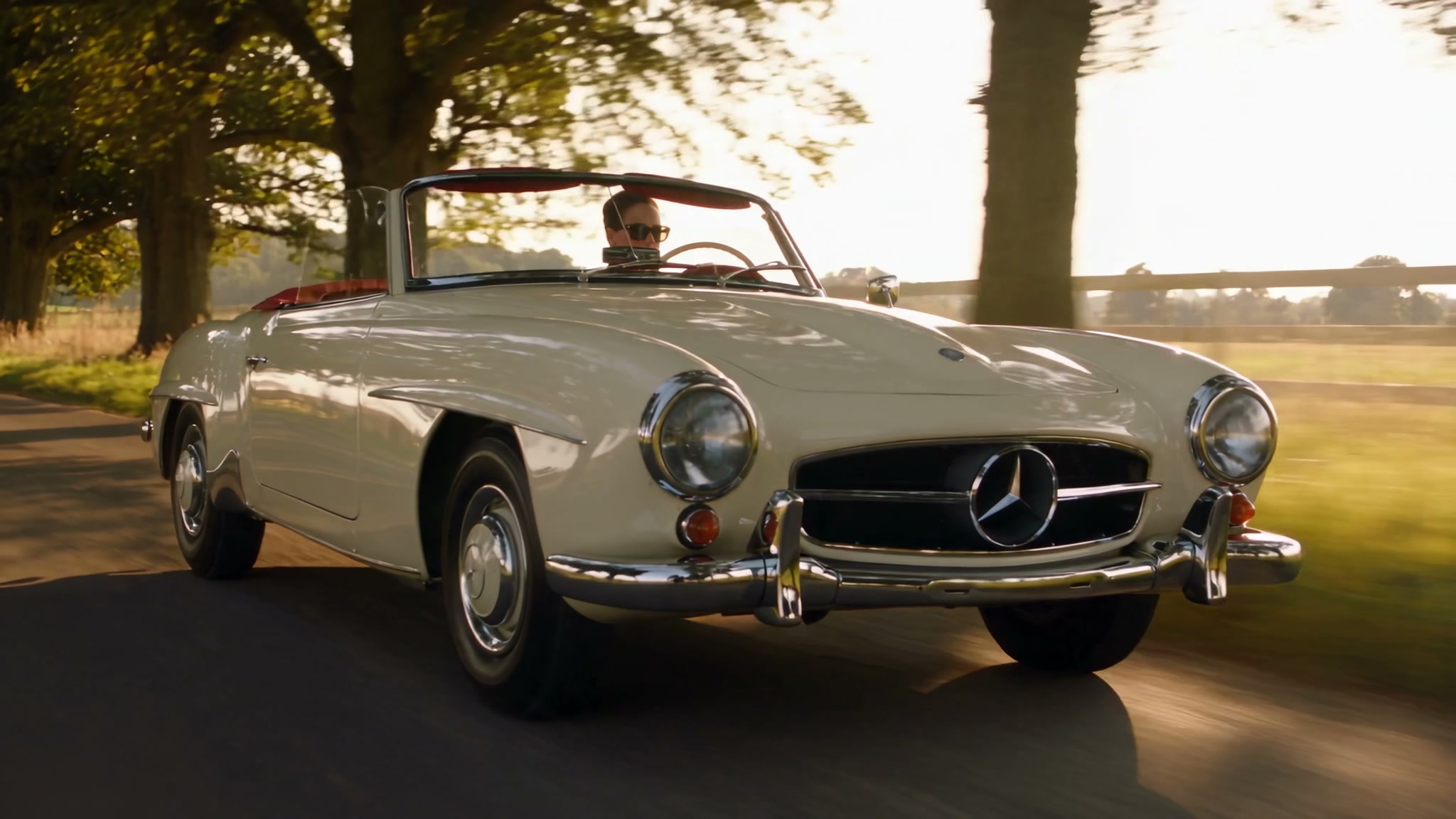 Bone Mercedes-Benz 190 SL on a tree-lined country avenue