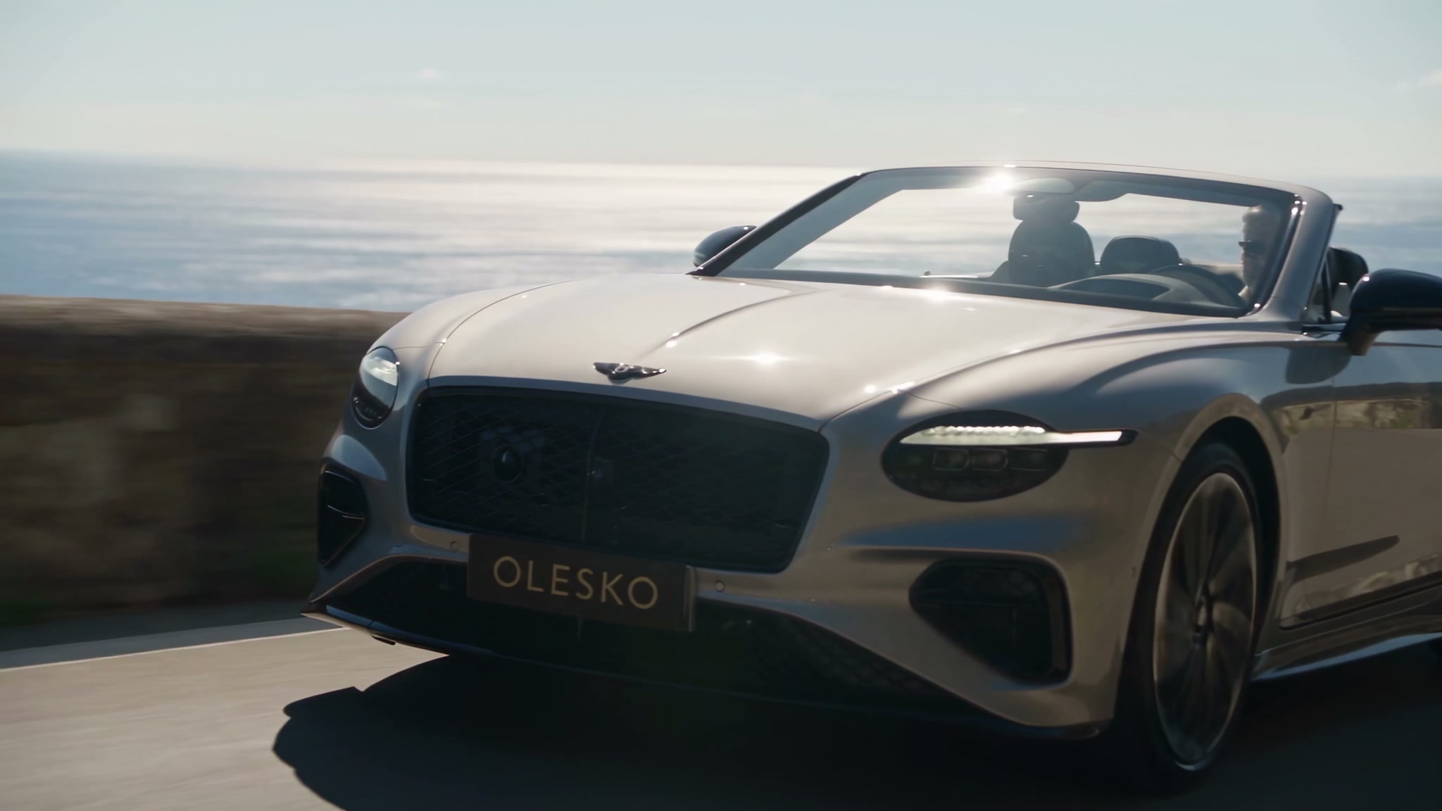 Silver Bentley Continental GTC on a Mediterranean cliff road