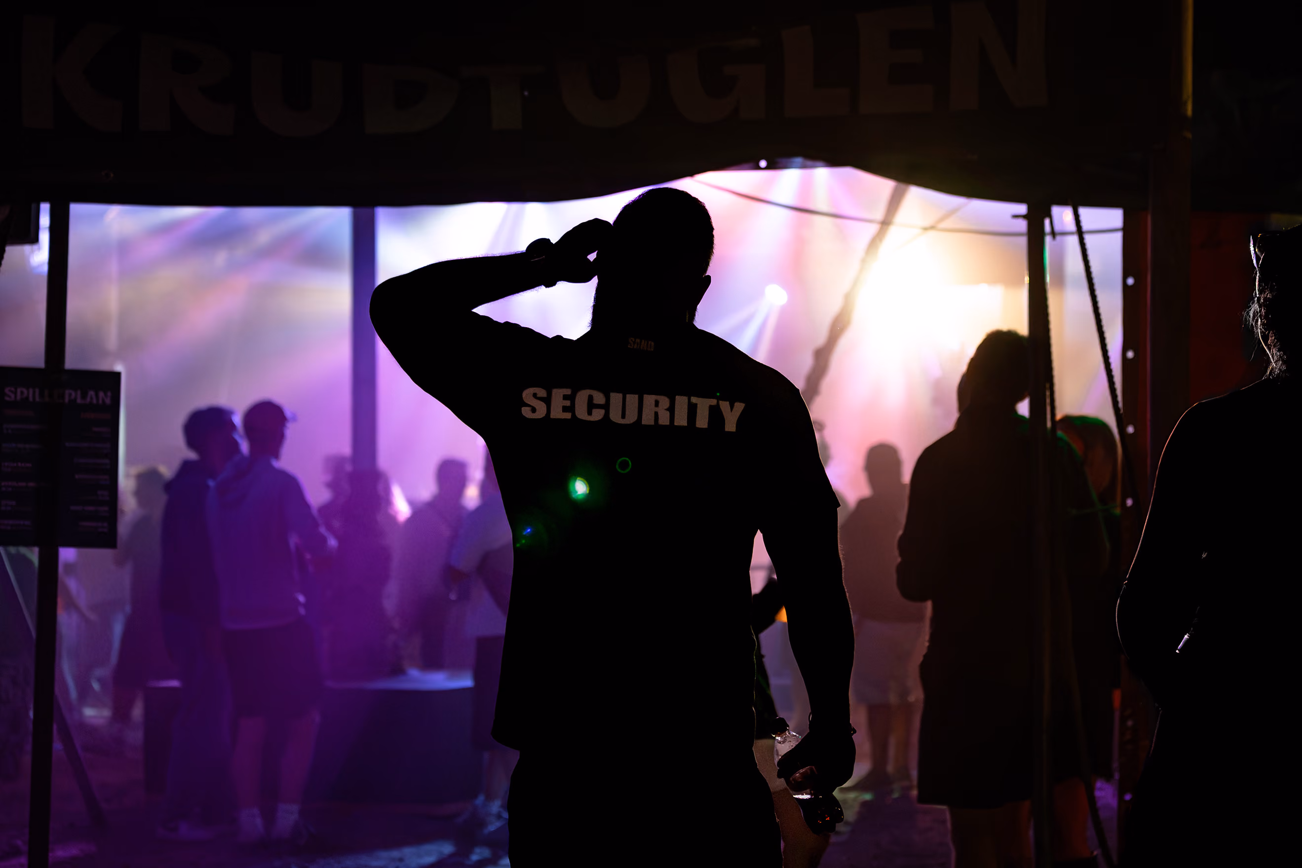 Sikkerhedsvagt kigger ind i et telt med publikum