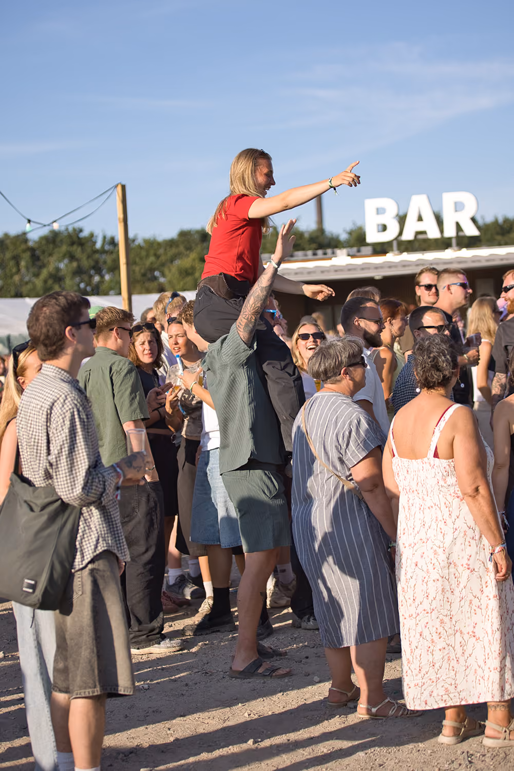 En gæst under en koncert sidder på skuldrene