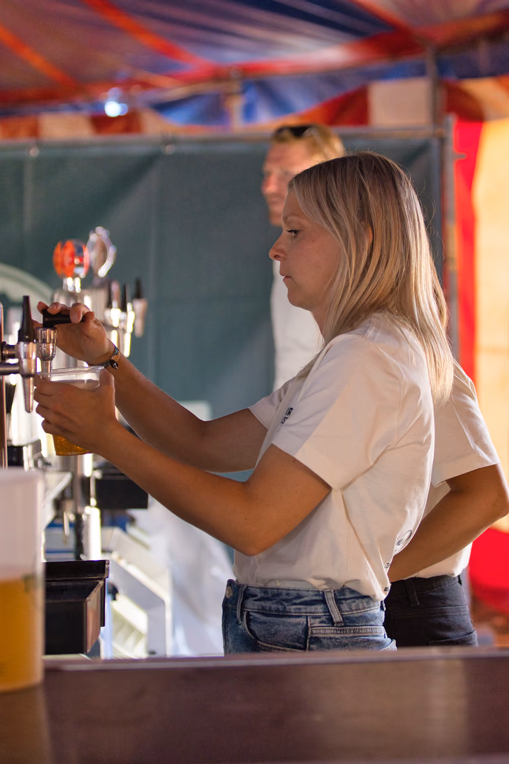 En bartender på Fjordlys Festival er ved at skænke en øl