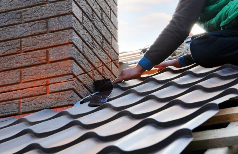 Construction worker installing a metal roof.