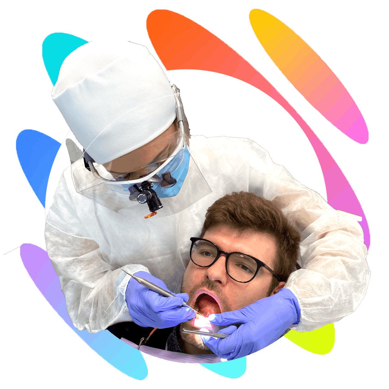 Dentist wearing PPE treats a male patient’s teeth using dental tools and magnification glasses.