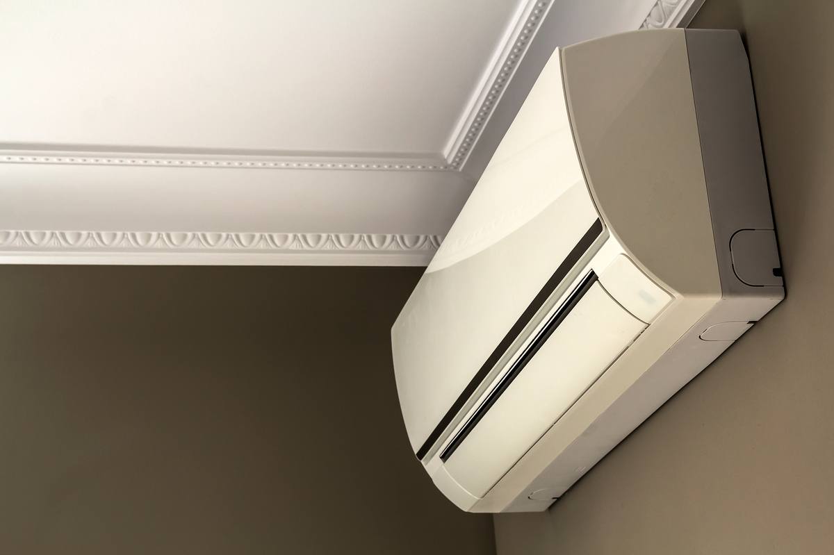 Ductless mini-split indoor unit on a dark interior wall