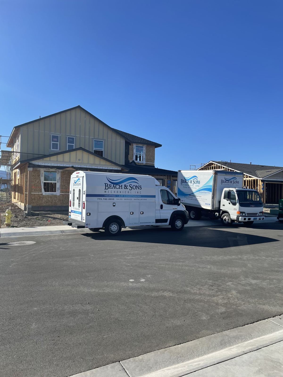 Two Beach and Sons trucks at a residential job in a neighborhood