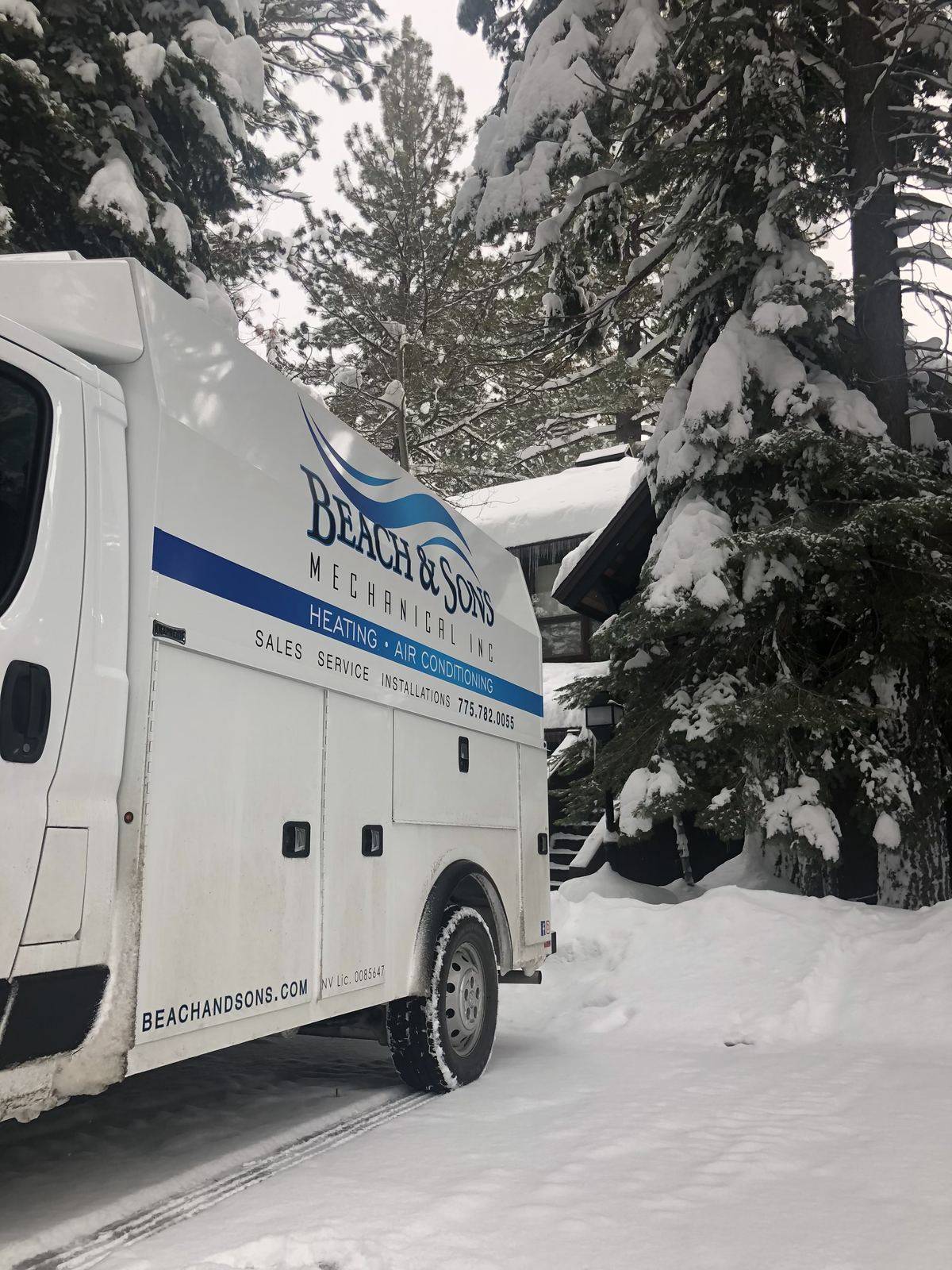 Beach and Sons service van parked in deep snow during a winter service call