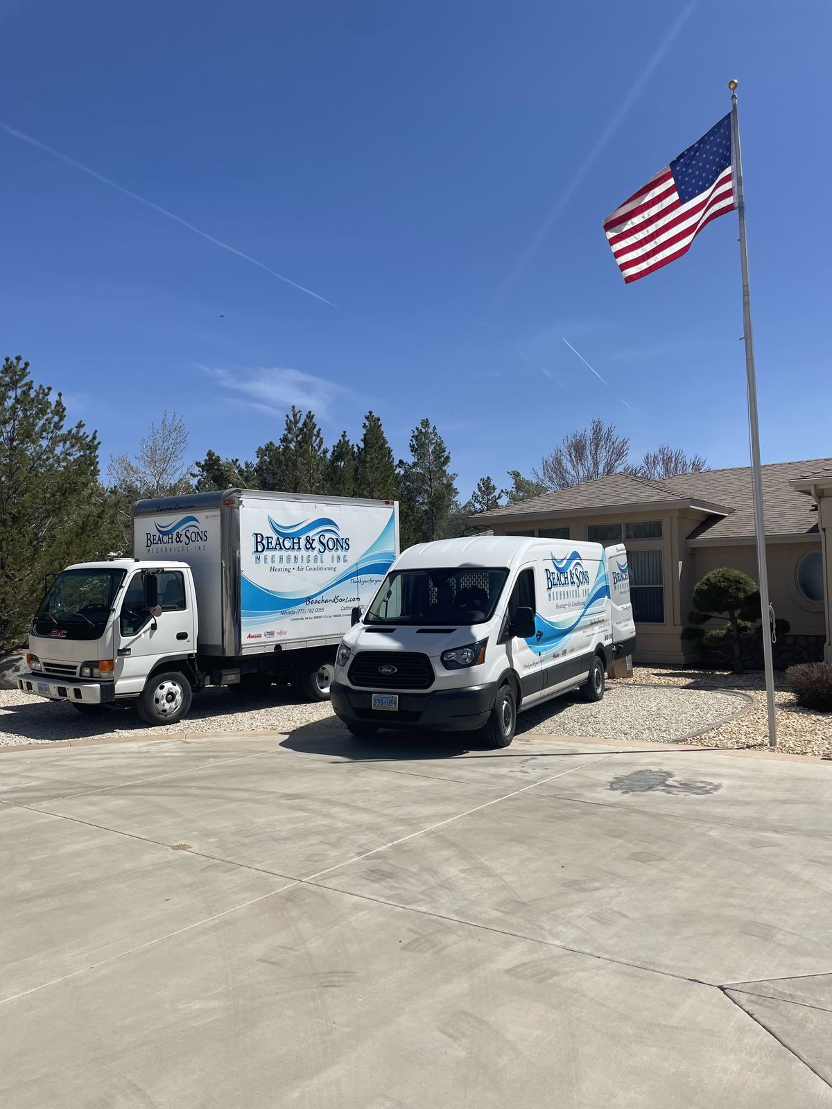 Beach and Sons trucks parked at the company office with an American flag