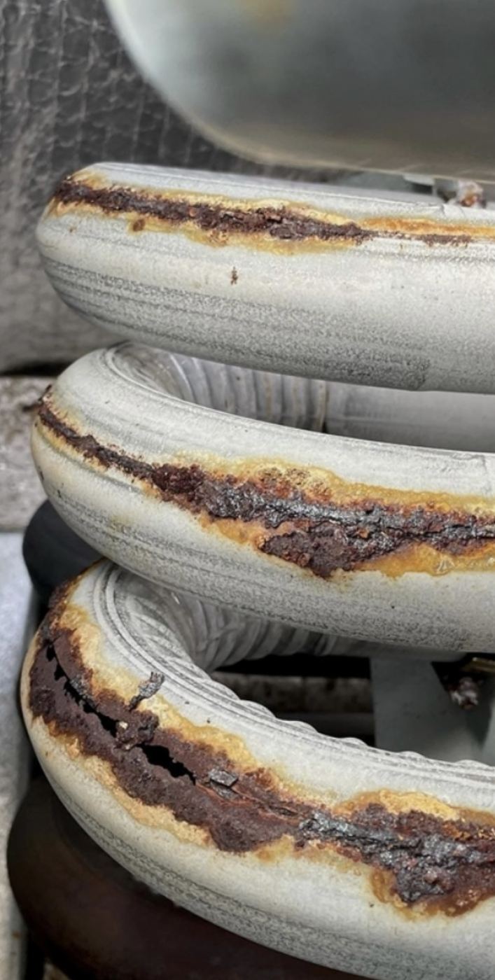 Close-up of corrosion and cracks along furnace heat exchanger tubes