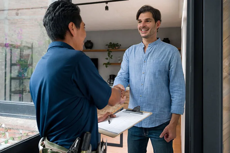 A tech shaking the hands of a customer.
