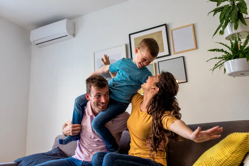A ductless minisplit behind a happy family 