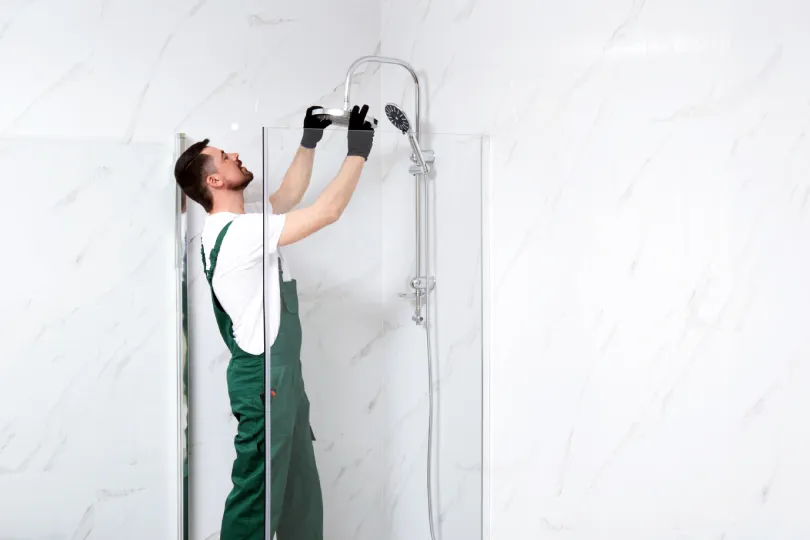 A technician working on installing a new shower head.