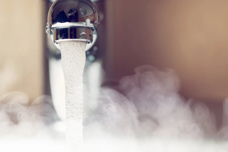 Hot water coming out of a faucet.