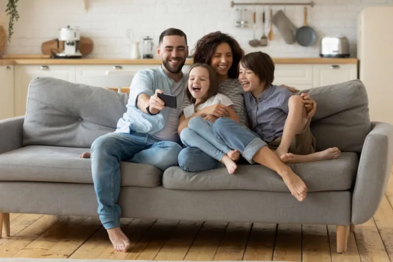A happy family sitting together on a couch.