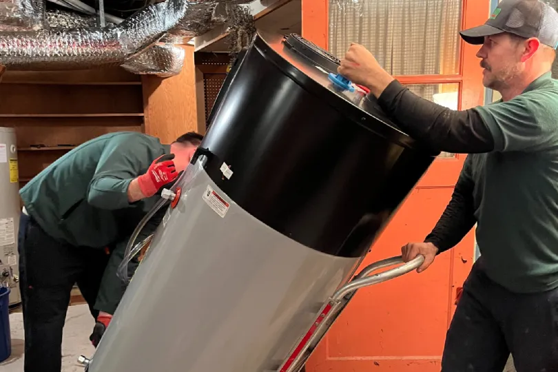 Two techs bringing in a new water heater into a customer's home.