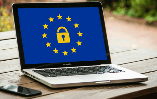 Kannettava tietokone, jonka näytöllä GDPR tietosuoja-asetukseen liittyvä logo